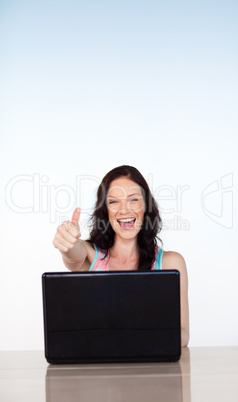 Happy smiling woman using her laptop with copy-space