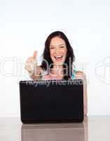 Happy woman with thumbs up using her laptop