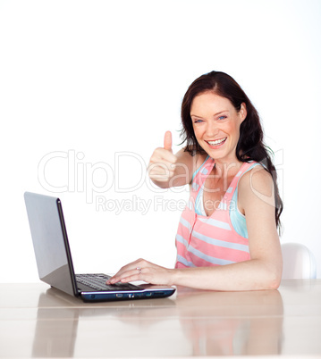 Happy woman having fun with laptop and thumb up