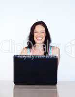 Woman working with a laptop smiling at the camera