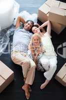 Parents and daughter on the floor with a lot of boxes
