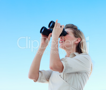 Blonde businesswoman looking through binoculars