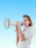 Attractive businesswoman shouting in a megaphone