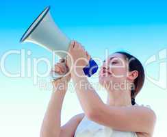 Attractive businesswoman shouting in a megaphone