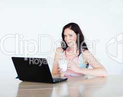 Woman using a laptop and drinking coffee