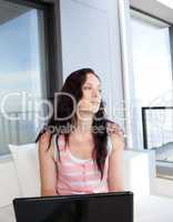 Thoughtful woman using her laptop