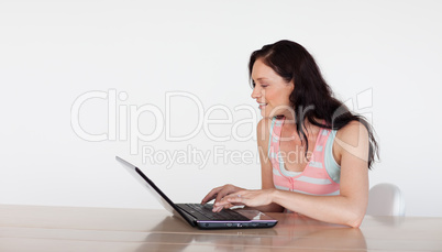 Smiling woman using her laptop with copy-space