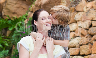 Portrait of a son kissing his mother in a park