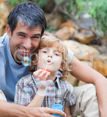 Portrait of a father and son blowing bubbles