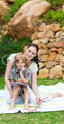 Mother and son painting in a park with copy-space