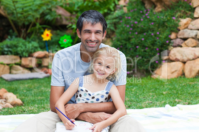 Father and daughter writing in a park