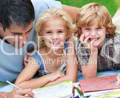 Smiling children drawing with their father