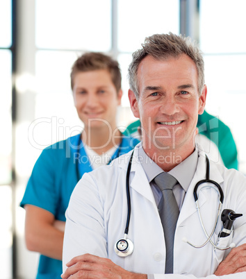 Portrait of a mature doctor leading his team