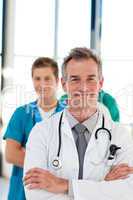 Mature doctor leading his team with copy-space