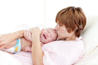 Mother kissing her newborn baby