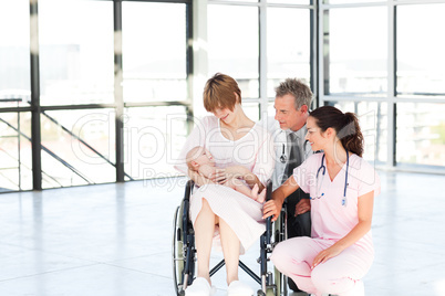 Mother with her newborn baby and doctors with copy-space