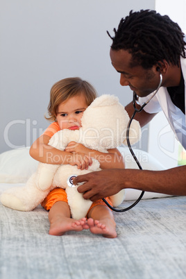 Pediatrician exams a little girl with stethoscope