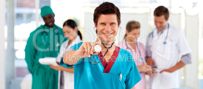 Friendly doctor with his team in the background