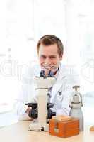 Male scientist looking through a microscope with copy-space