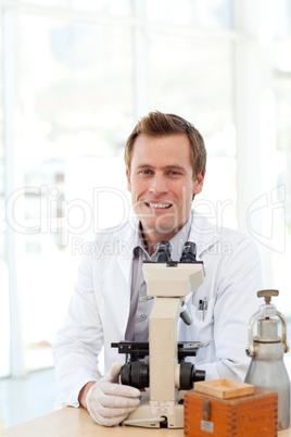 Male scientist looking at a slide under a microscope