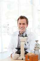 Male scientist looking at a slide under a microscope