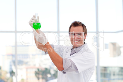 Smiling scientist examining a chemical test-tube