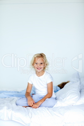 Little girl sitting in bed with copyspace