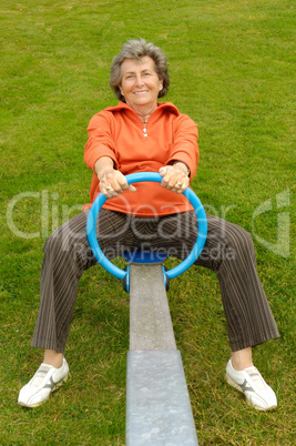 Seniorin auf einem Spielplatz