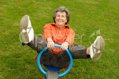 Seniorin auf einem Spielplatz