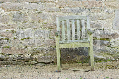 Alter Stuhl vor Natursteinmauer