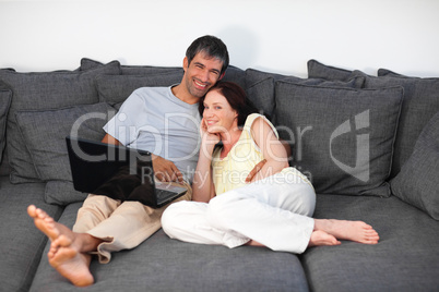 Couple laying on couch with laptop