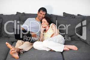 Couple laying on couch with laptop