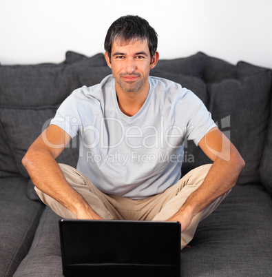 Man using laptop looking at camera