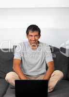 Man using laptop looking at camera