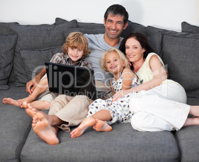 Family on a sofa with laptop