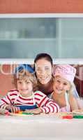 Mother with her Two Kids looking at the camera smiling