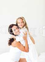 Mother and daugther embracing on bed
