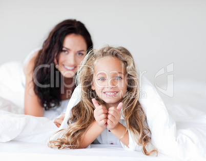 Mother and daugther embracing on bed