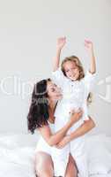 Mother and daugther embracing on bed