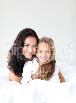 Mother and daugther embracing on bed