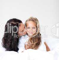 Mother and daugther embracing on bed