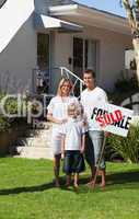Happy Family holding Sold Sign