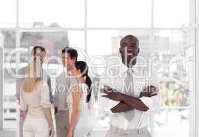 Young African - American Business leader standing inf front of business team smiling