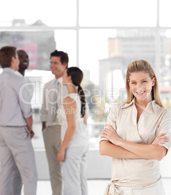 Business woman in front of a group of associates smiling