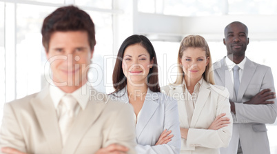 Business man with arms folded in front of Business Team