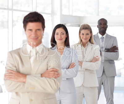Business man with arms folded in front of Business Team
