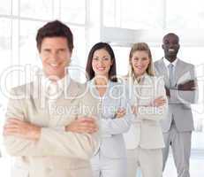 Business man with arms folded in front of Business Team