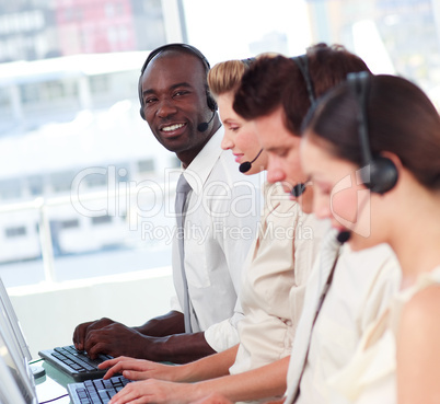 Man smiling at camera in a call centre