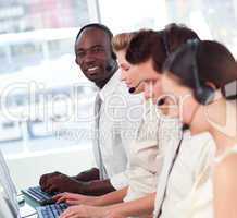 Man smiling at camera in a call centre