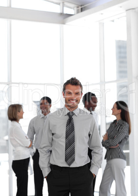 Potrait of a businessman standing before team